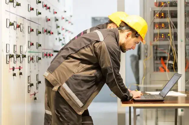 Two men in hard hats working somewhere industrial